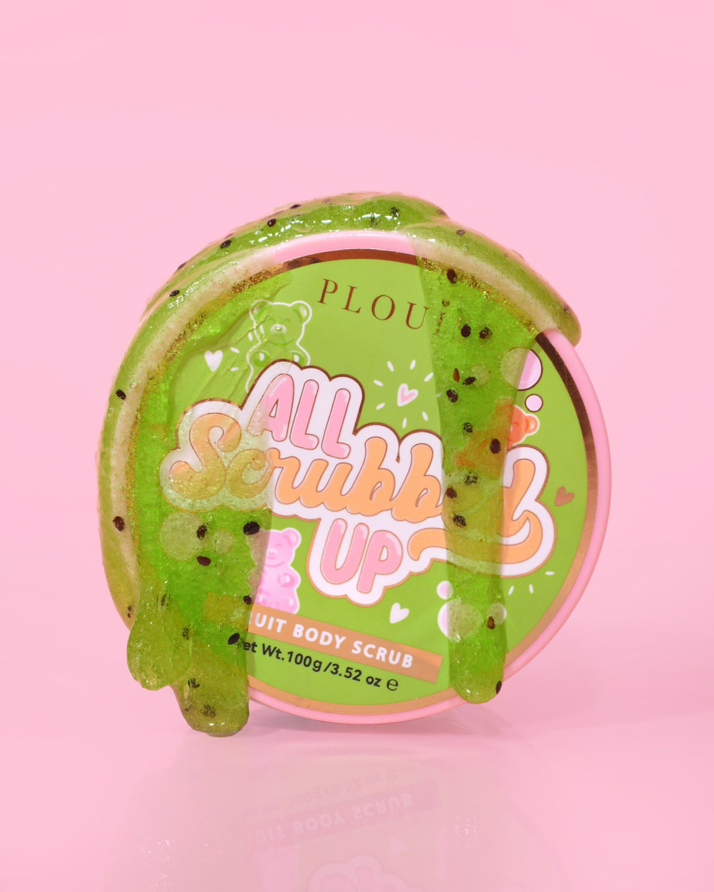 Opakowanie P.Louise All Scrubbing Up Body Scrub z etykietą „Candy Bears” na różowym tle i produktem w postaci zielonego żelu
