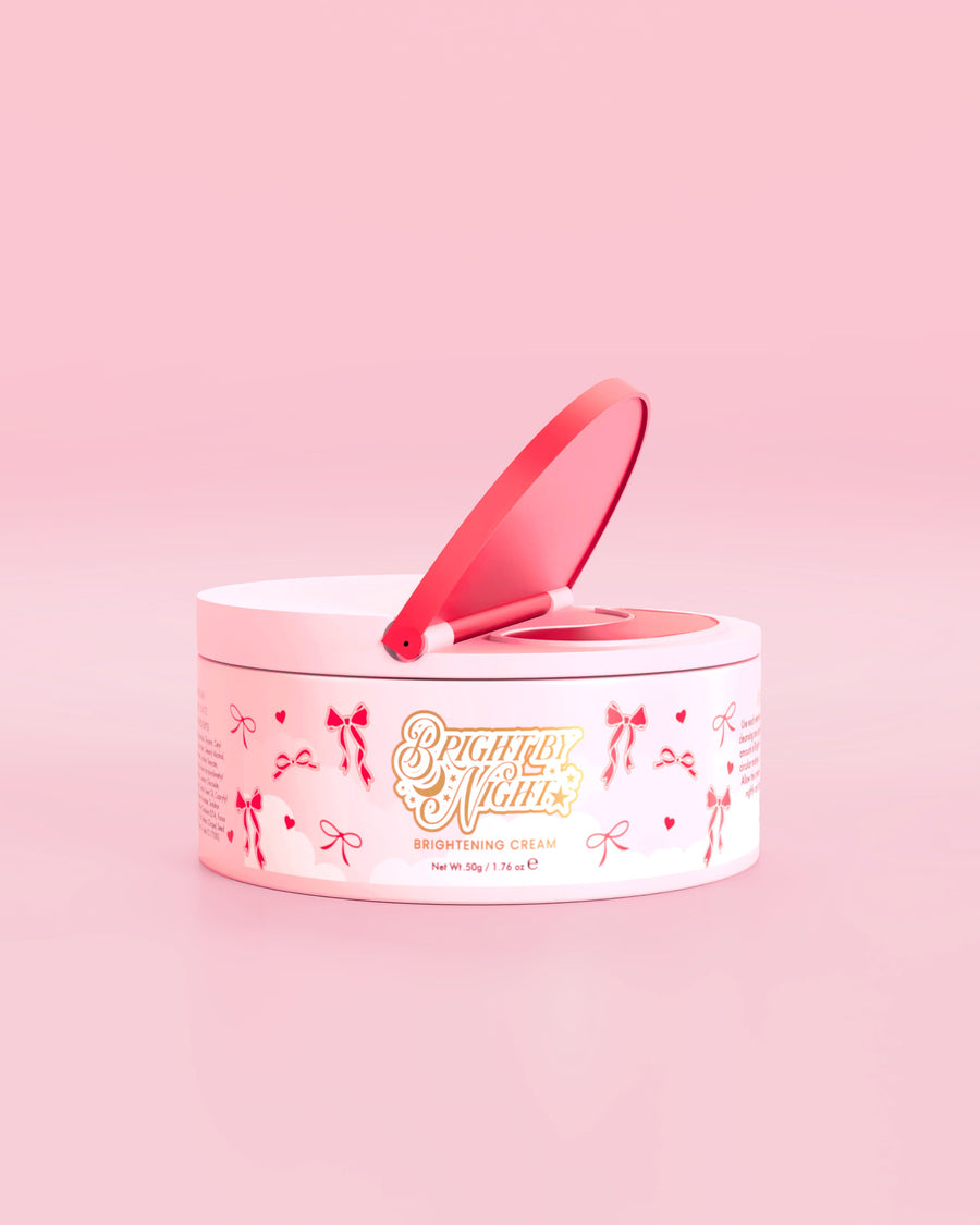 Różowa tuba kremu rozjaśniającego P.Louise Bright By Night z elementami graficznymi z czerwoną kokardką na różowym tle