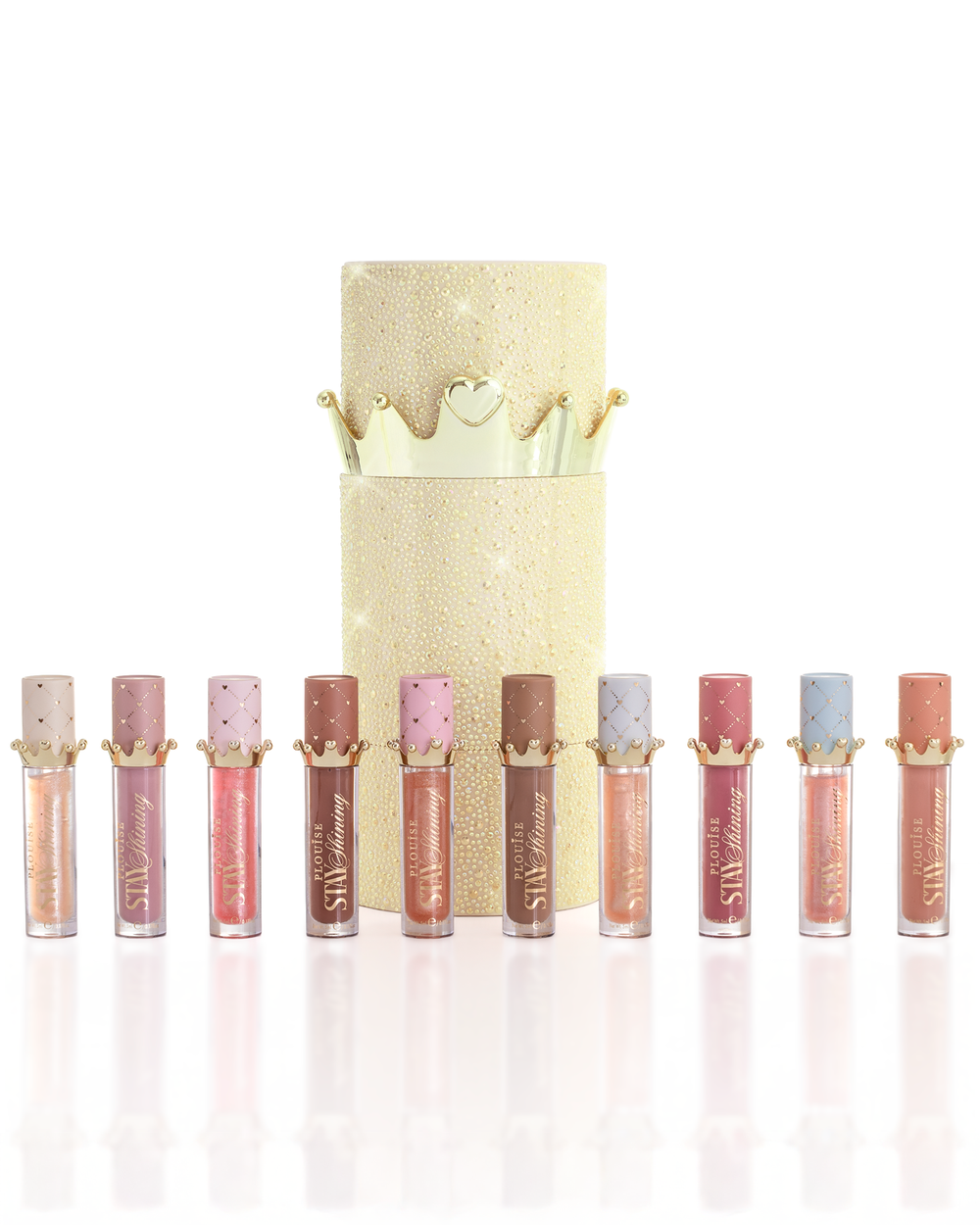 Zestaw dziesięciu produktów P.Louise Christmas Stay Shining Lip Oil ułożonych w rzędzie przed błyszczącym złotym cylindrycznym pudełkiem z olejkiem do ust ze złotą pokrywką, na czystym białym tle.