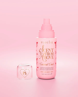 Pink bottle of 'Scent from Above' hair and body mist with red bow designs on the bottle and the cap off