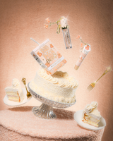 Tort na pluszowym stole z P.Louise Teddy Glitter Bad Bitch Energy Lip Duo w torcie kokosowym zawierającym odżywkę do ust i olejek do ust unoszący się po torcie 