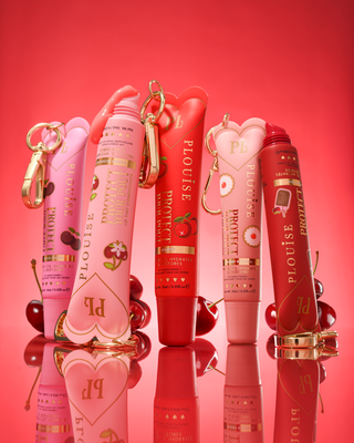 Set of P.Louise cherry scented tinted protect your pout lip conditioner tubes on a red background